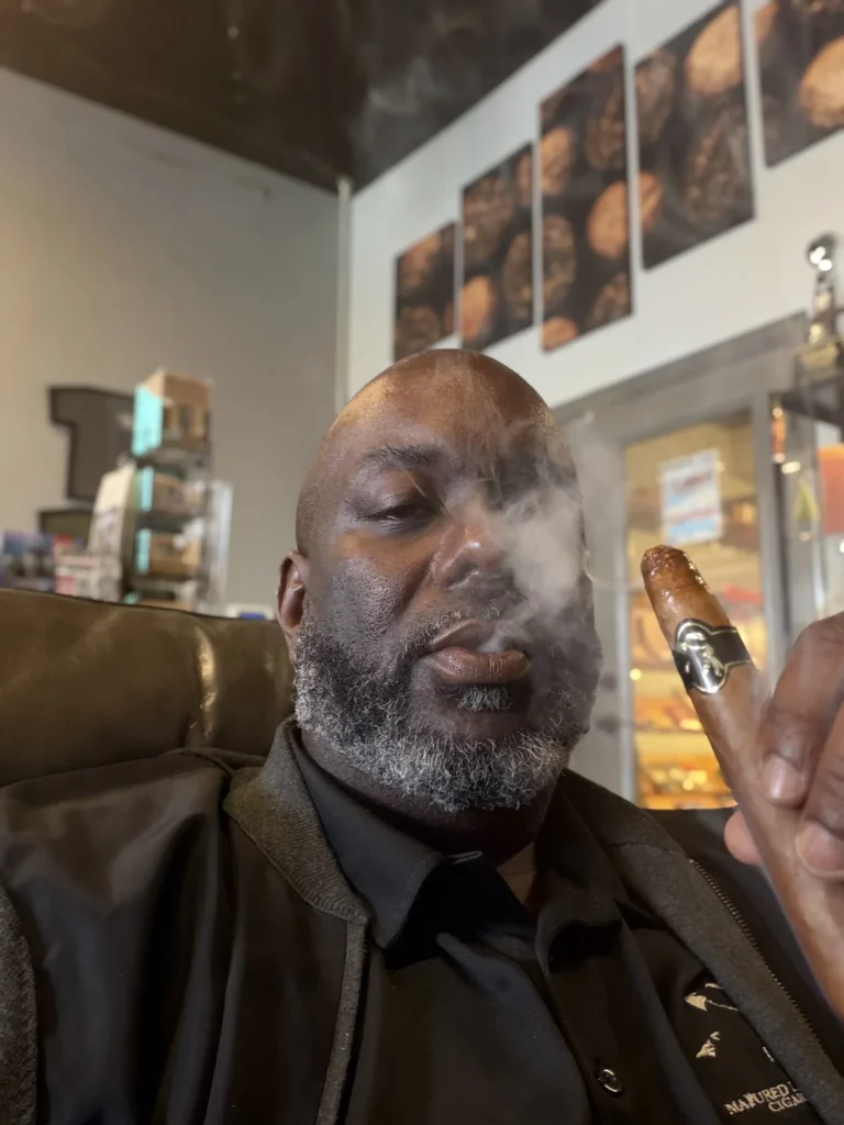 Shawn Jones, founder of Phruition Cigars, holding a light cigar